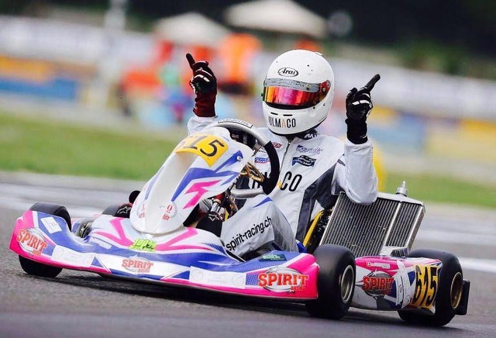 Pilote de la Rohrbasser Driving School en kart de compétition, les deux index levés pour célébrer sa victoire